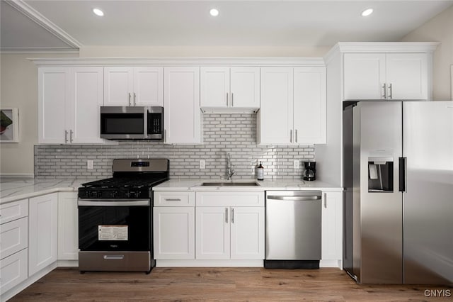 kitchen featuring white cabinetry, decorative backsplash, sink, and appliances with stainless steel finishes