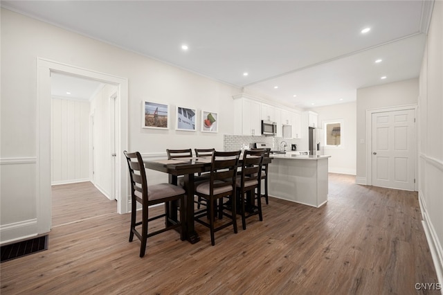 dining area featuring dark hardwood / wood-style floors and ornamental molding