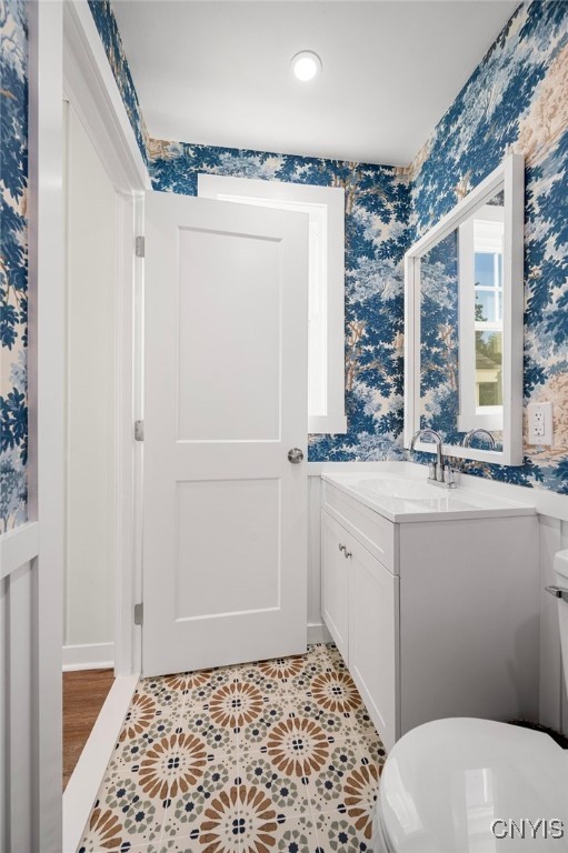 bathroom with toilet, vanity, and tile patterned floors