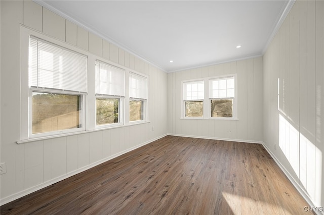 empty room with wood-type flooring and crown molding