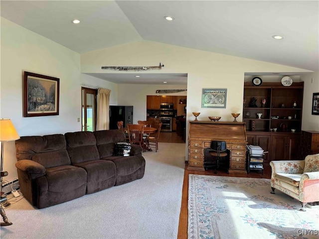 living room featuring light colored carpet, vaulted ceiling, and a baseboard heating unit