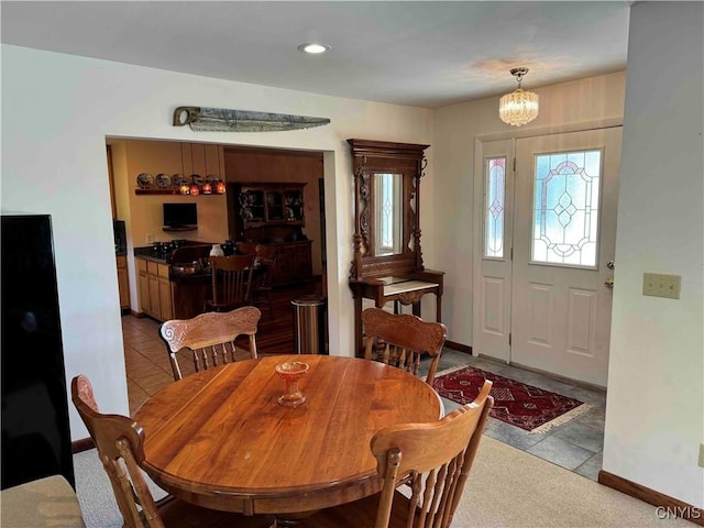 dining area with a chandelier and light tile patterned floors