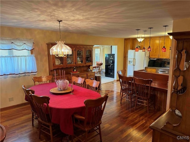 dining area featuring an inviting chandelier and dark wood-type flooring