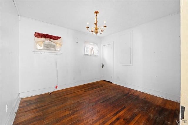 empty room featuring dark wood-type flooring and an inviting chandelier