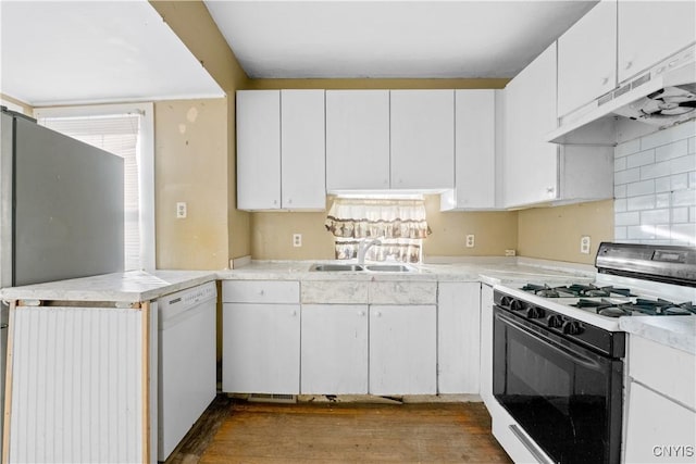 kitchen with sink, dark hardwood / wood-style floors, kitchen peninsula, white appliances, and white cabinets