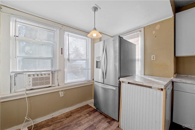 kitchen featuring stainless steel refrigerator with ice dispenser, radiator, cooling unit, light hardwood / wood-style floors, and hanging light fixtures