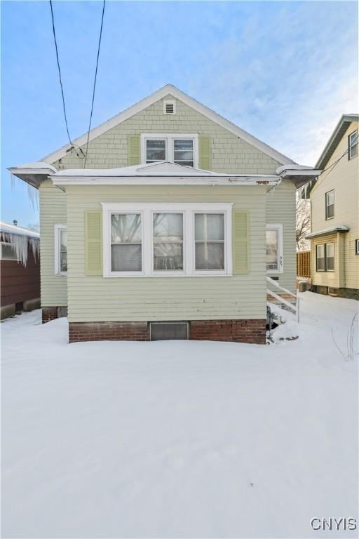 view of snow covered back of property