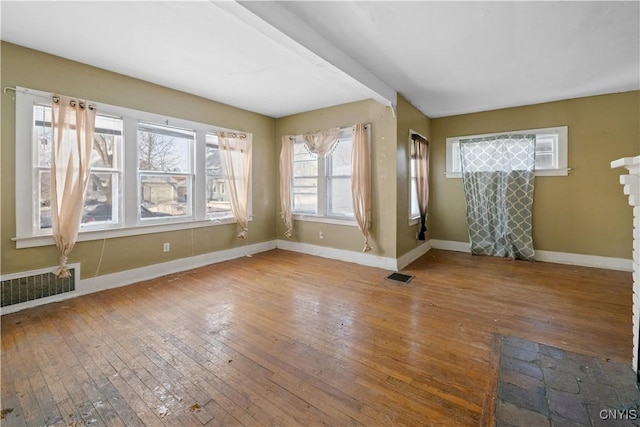 spare room featuring hardwood / wood-style flooring and a healthy amount of sunlight