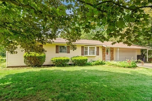 ranch-style house with a front yard and a garage