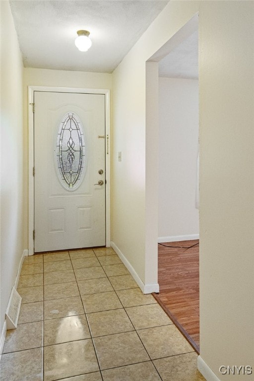 doorway with light tile patterned flooring