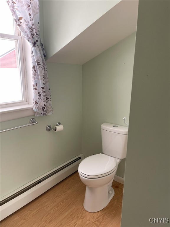 bathroom with toilet, hardwood / wood-style flooring, and a baseboard radiator