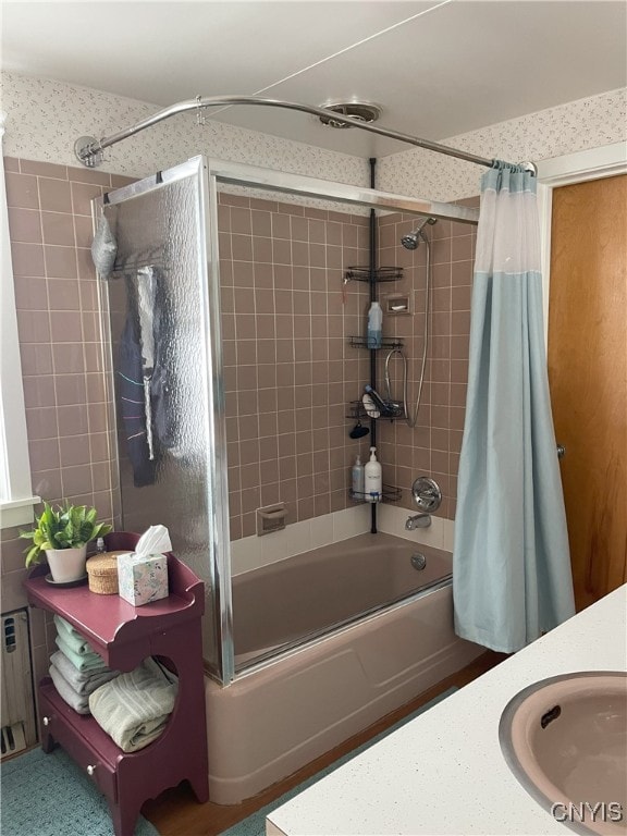 bathroom featuring shower / bath combo with shower curtain, sink, and radiator heating unit