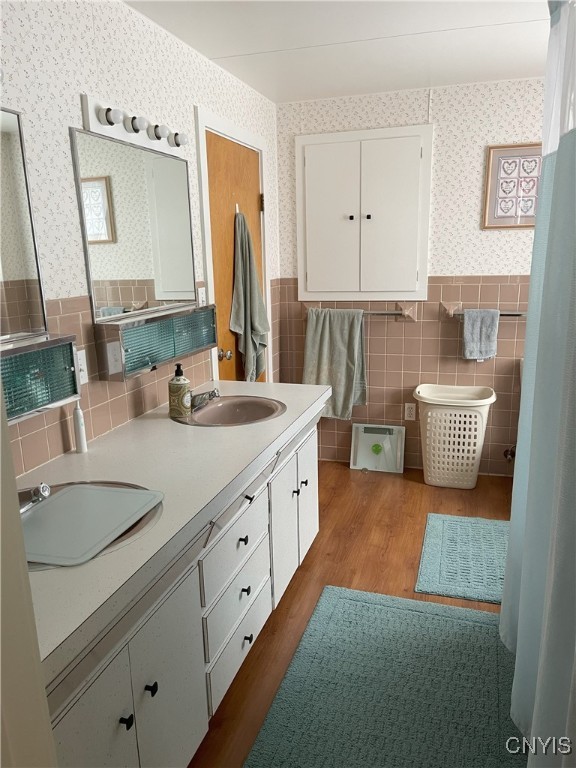 bathroom featuring tile walls, wood-type flooring, and vanity