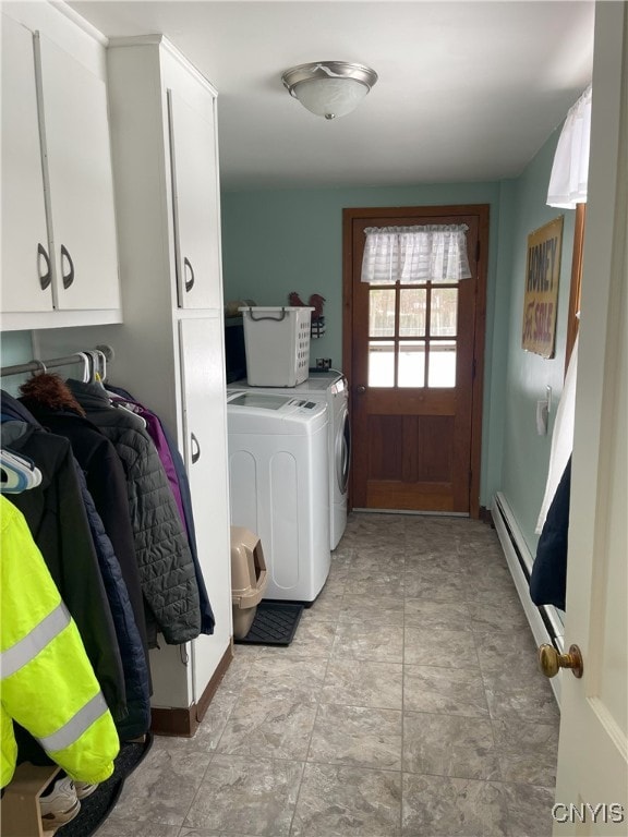 laundry room featuring a baseboard heating unit, separate washer and dryer, and cabinets