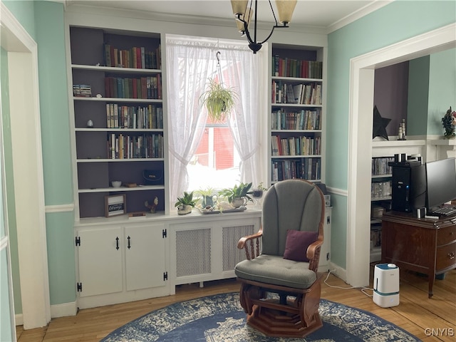 living area featuring radiator, plenty of natural light, ornamental molding, and light hardwood / wood-style flooring