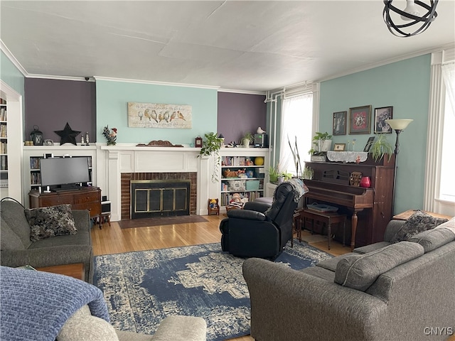 living room with hardwood / wood-style floors, crown molding, and a fireplace