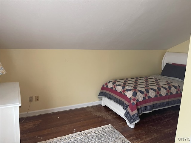 bedroom with dark wood-type flooring and vaulted ceiling