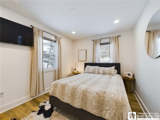 bedroom featuring multiple windows and wood-type flooring