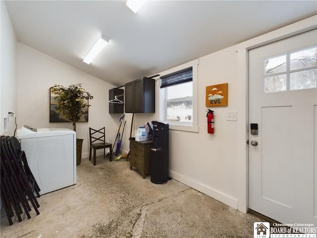 clothes washing area featuring washer / clothes dryer and cabinets