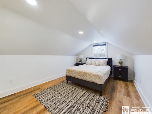 bedroom with hardwood / wood-style floors and vaulted ceiling