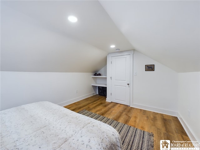 bedroom featuring wood-type flooring and lofted ceiling