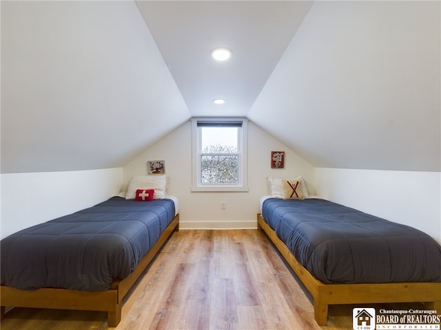 bedroom with light wood-type flooring and vaulted ceiling