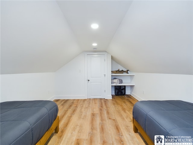 bedroom with light hardwood / wood-style flooring and lofted ceiling