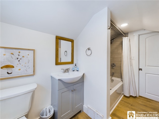 full bathroom with shower / tub combo, vanity, vaulted ceiling, wood-type flooring, and toilet