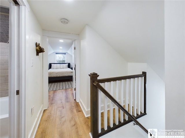 hallway featuring light hardwood / wood-style floors and vaulted ceiling