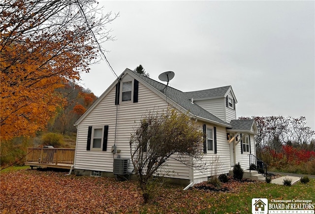 view of side of property featuring a wooden deck and central AC unit