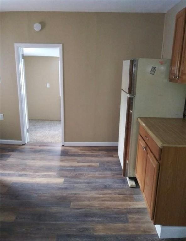 kitchen featuring white fridge and dark wood-type flooring