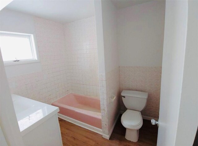 bathroom featuring hardwood / wood-style floors, vanity, toilet, and tile walls