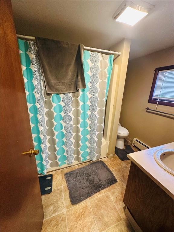 full bathroom featuring baseboard heating, shower / bathtub combination with curtain, vanity, and toilet