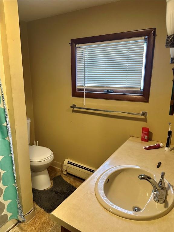 bathroom with baseboard heating, tile patterned flooring, vanity, and toilet