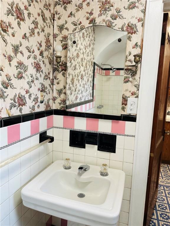 bathroom featuring tile walls and sink