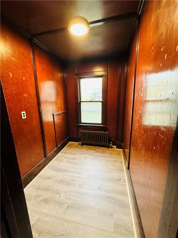 hallway with radiator and light hardwood / wood-style flooring