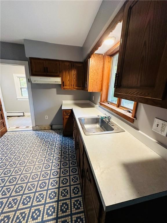 kitchen featuring dark brown cabinetry, a baseboard radiator, and sink