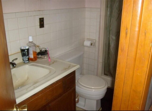 bathroom featuring curtained shower, vanity, tile walls, and toilet