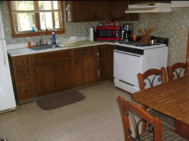 kitchen featuring white range with gas cooktop and sink