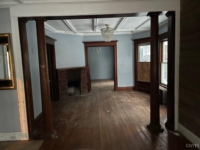 hallway with dark wood-type flooring, a chandelier, and ornate columns