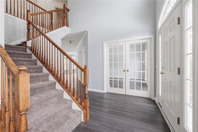 entrance foyer with dark hardwood / wood-style floors, a high ceiling, and french doors