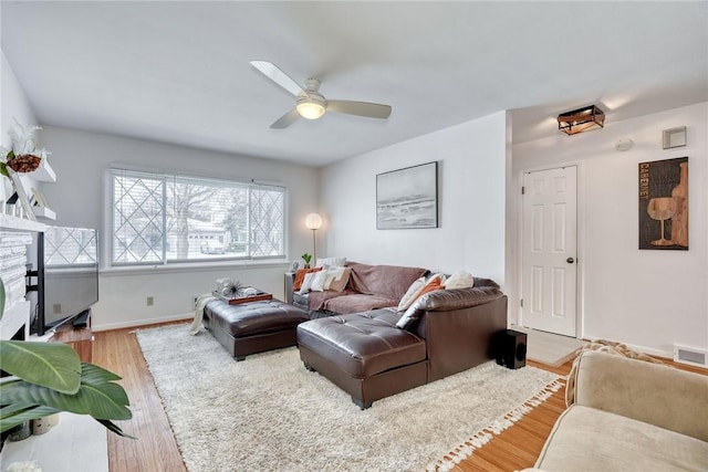 living room with ceiling fan and light hardwood / wood-style flooring