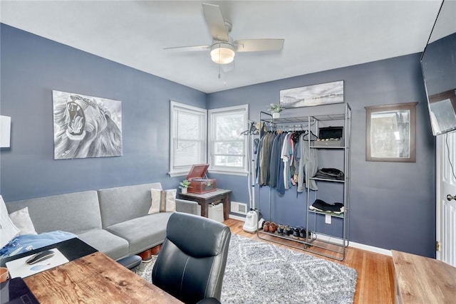 living room featuring ceiling fan and hardwood / wood-style floors