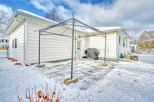 view of snow covered exterior featuring central AC unit