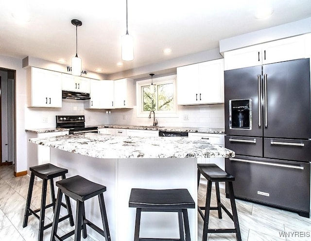 kitchen featuring a kitchen island, light stone counters, decorative light fixtures, white cabinets, and black appliances