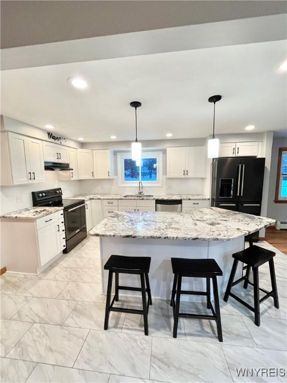 kitchen featuring black appliances, sink, white cabinetry, and hanging light fixtures