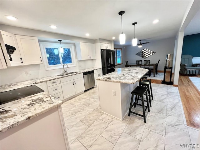 kitchen featuring white cabinets, a center island, sink, and black appliances