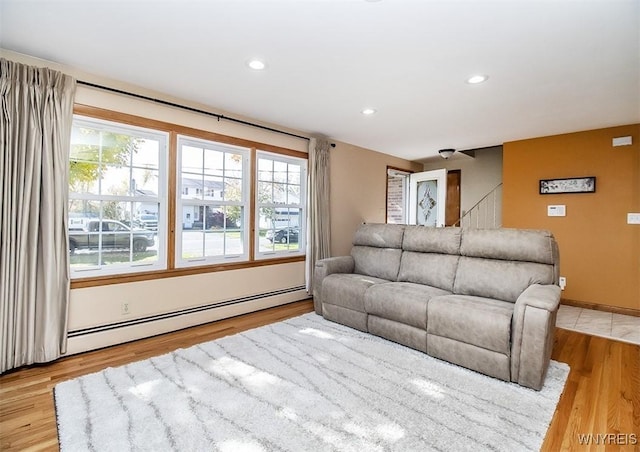 living room with light wood-type flooring and a baseboard heating unit