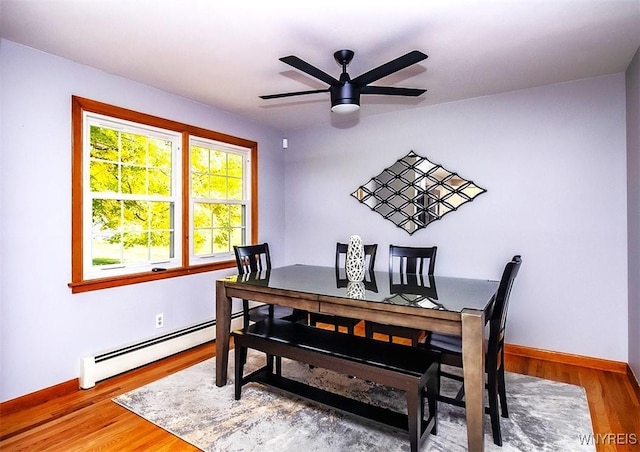 dining space with baseboard heating, ceiling fan, and hardwood / wood-style flooring