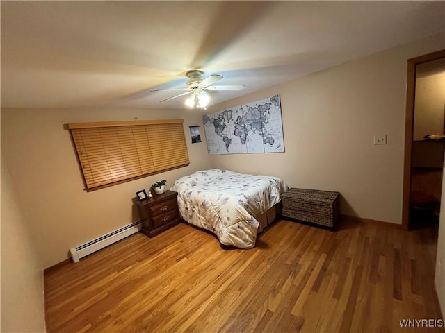 bedroom with hardwood / wood-style flooring, baseboard heating, and ceiling fan